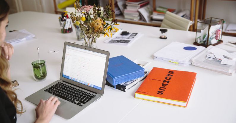 HR Technology - Photo Of Orange Book Beside Laptop