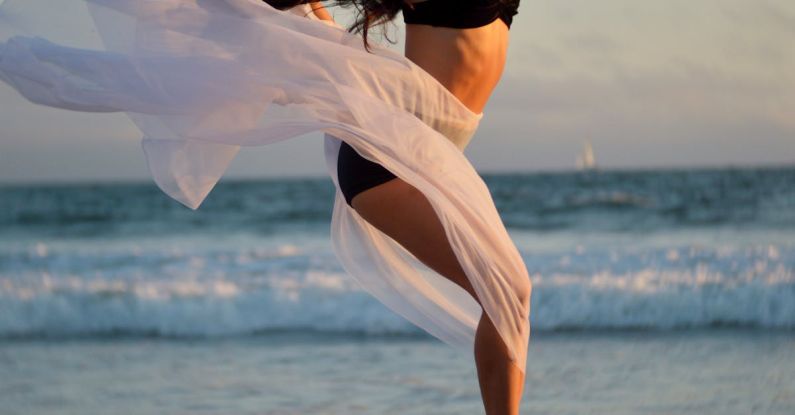 Talent Retention - Skinny dancer jumping over sandy shore of ocean