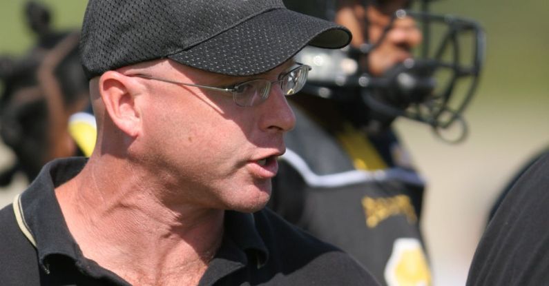 Leadership Coaching - Man in Black Polo Shirt Wearing Black and Yellow Snapback Near Man in Black and Yellow Football Jersey during Daytime