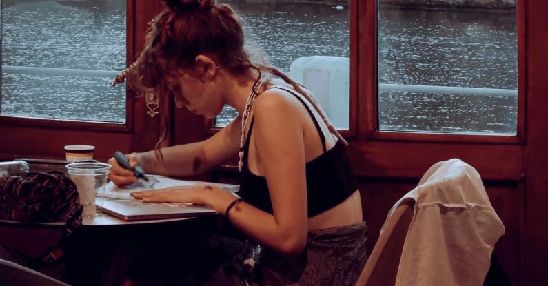 Continuous Learning - A woman sitting at a table writing in a notebook