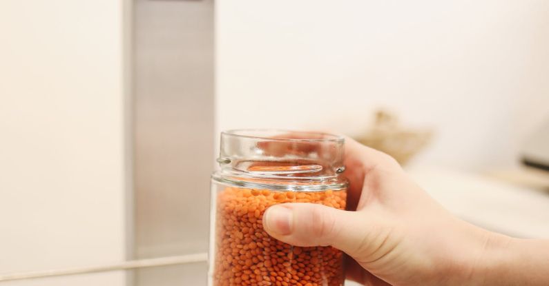 Ethical Business - Person Holding Clear Glass Jar With Brown Substance