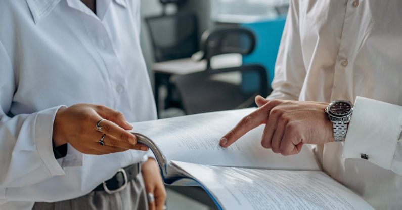 Workflow Management - Colleagues Standing in White Long Sleeve Shirts Discussing and Reading a Financial Report