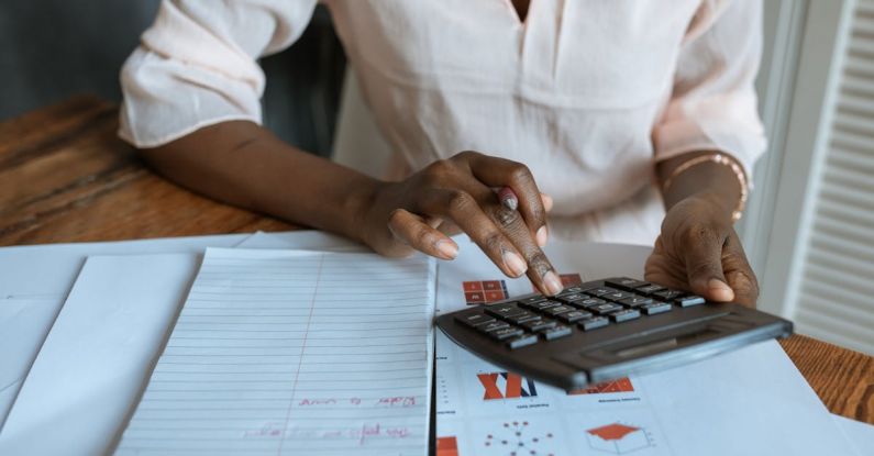 Startup Financing - Person in White Dress Shirt Using A Calculator