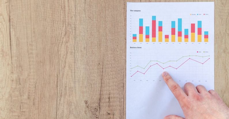 Financial Analytics - Person Pointing Paper Line Graph