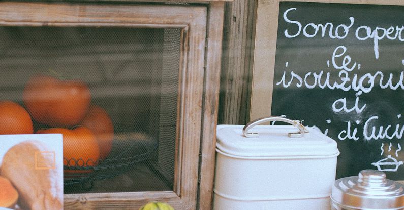 Small Business Marketing - Through glass view of store front of utensils shop decorated with vegetables and small blackboard